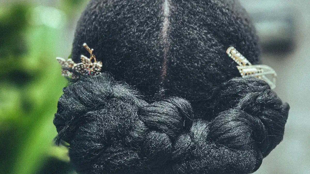 Rear view of a braided updo hairstyle decorated with jewelled gold hair accessories