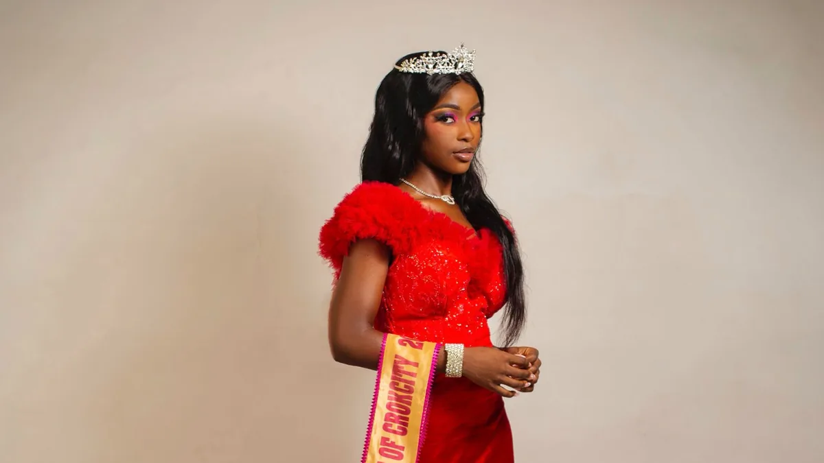 Pageant contestant in an elegant red evening gown and tiara on stage at a local beauty pageant